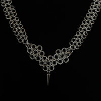 a silver chain necklace with a spike on it