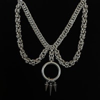 a silver chain necklace with spikes on it